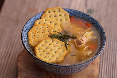 High angle view of soup with crackers on wooden table