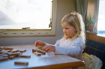 Girl sitting on table at home