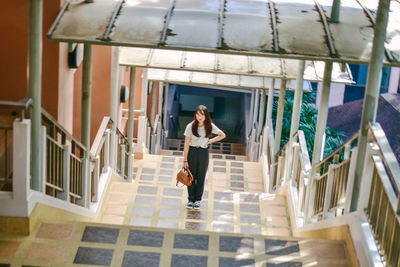 Full length of woman on staircase against building