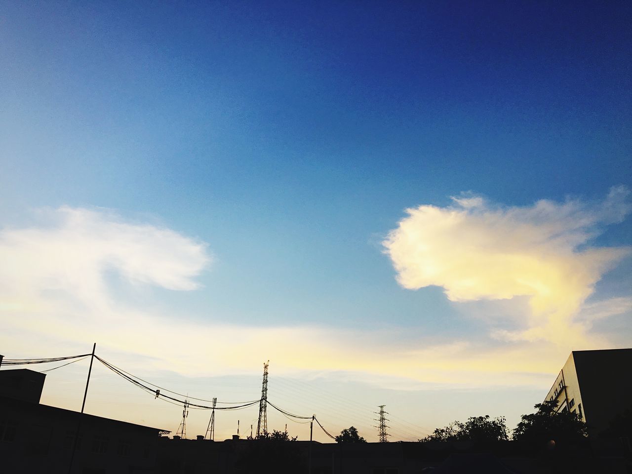 low angle view, sky, built structure, architecture, sunset, cloud - sky, blue, high section, cloud, outdoors, nature, no people, cloudy, day, beauty in nature, development, tranquility, scenics