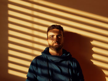 Portrait of man standing against wall