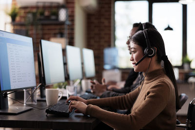 Customer service representative with colleague working at desk