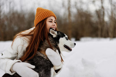 Woman embracing dog during winter