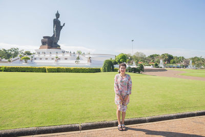 Woman standing on footpath against sky