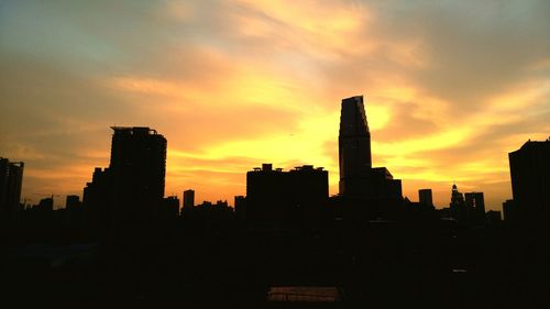 Silhouette of buildings against sky at sunset