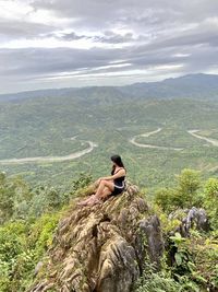 Gurl sitting on mountain rock 