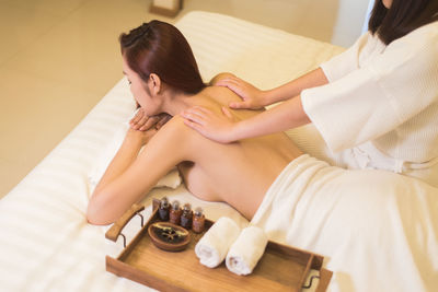 Midsection of woman giving back massage to customer in spa