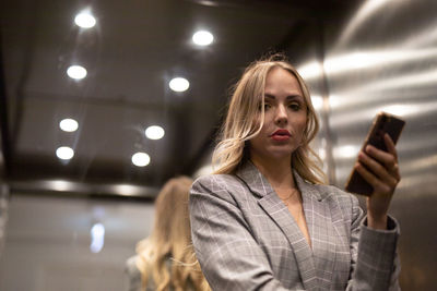 Portrait of young woman standing in city