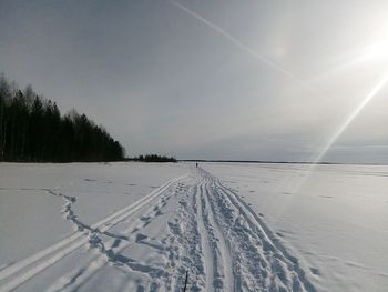 Snow covered landscape against sky