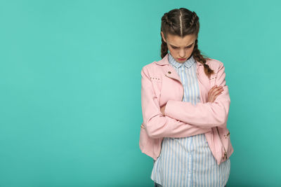 Young woman standing against blue background