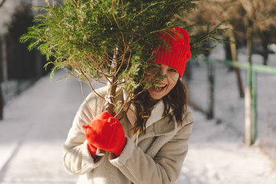 Midsection of woman holding christmas tree