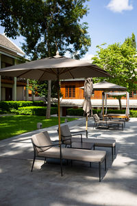 Chairs and tables in swimming pool against building