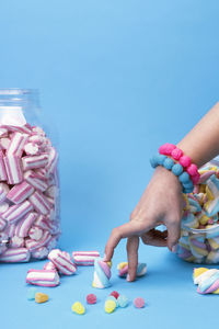 Female hand using chopsticks with candy sushi