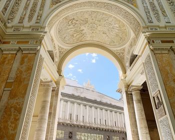 Low angle view of historical building seen through arch against sky