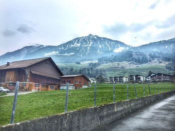 Houses on landscape by mountain