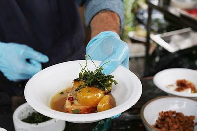 Midsection of man holding meat in bowl at table