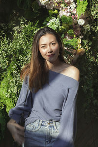 Portrait of beautiful woman against plants