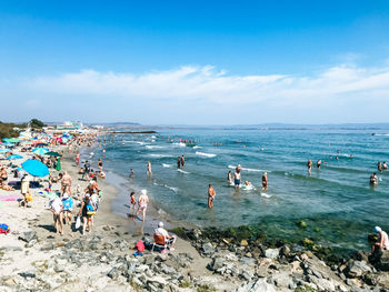 Group of people on beach against sky