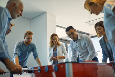 Colleagues playing foosball in office