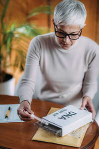 Midsection of man holding eyeglasses on table