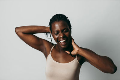 Portrait of smiling young woman against white background