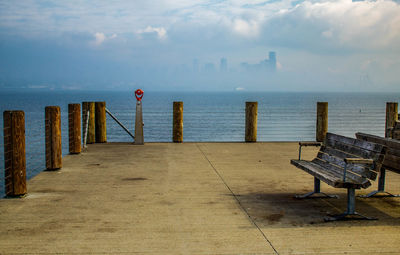 Wooden posts on beach against sky