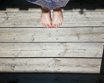 Low section of woman standing on wood