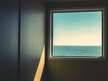 Close-up of sea against sky seen through window