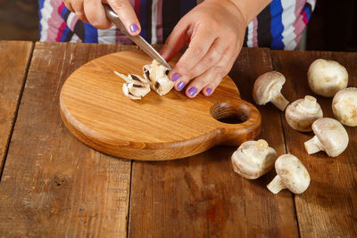 Cropped hand of person preparing food on table