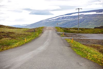 Empty road against cloudy sky