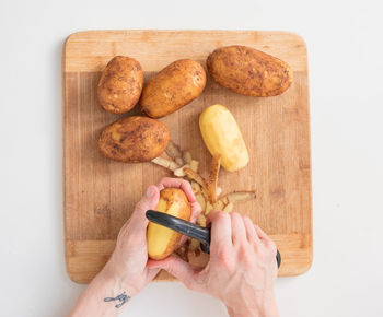 High angle view of hand holding bread on cutting board