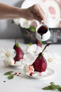 Spicy pears cooked in red wine with vanilla ice cream on white dishes,delicious