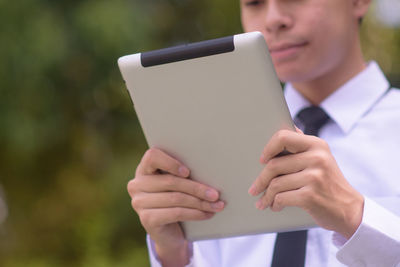 Midsection of man using tablet