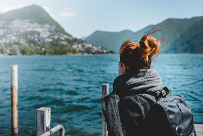Rear view of woman in lake against mountains