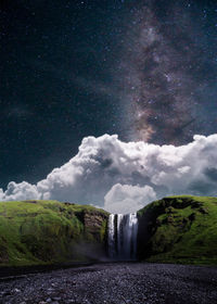 Scenic view of waterfall against sky at night