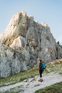 Full length of woman standing on rock formation against sky