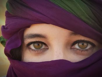 Close-up portrait of woman covering face with scarf 