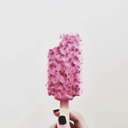 Cropped image on woman holding strawberry ice cream over white background