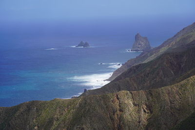 Scenic view of sea and mountains against sky