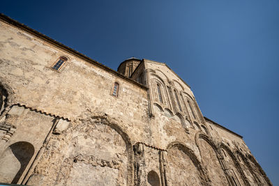 Low angle view of old building against clear blue sky