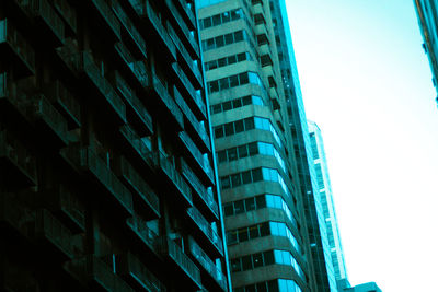 Low angle view of skyscrapers against blue sky