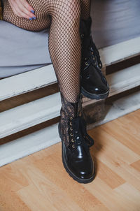 Low section of woman wearing stockings while sitting on floor