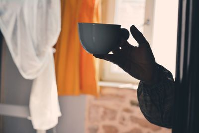 Midsection of man holding coffee cup