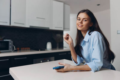 Portrait of young woman using laptop at home