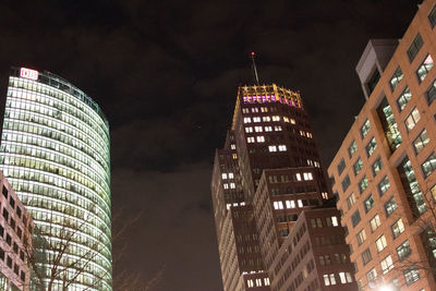 Low angle view of illuminated buildings against sky at night