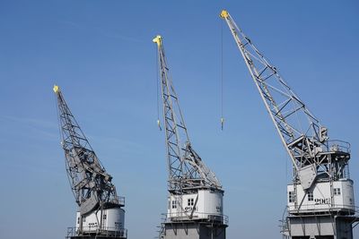 Low angle view of crane against clear sky