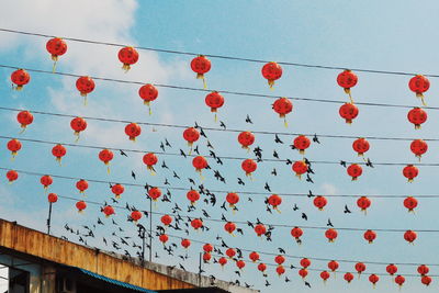 Low angle view of lanterns hanging against sky