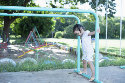 Side view of woman standing on slide at playground