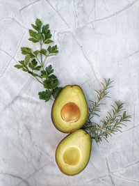 Fresh avocado with herbs and lemons lies on the table on white background. flat lay. top view.