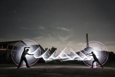 Digital composite image of people with umbrella against sky